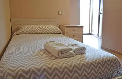 a bedroom with a bed with two towels on it at Hotel Rural Val Dos Pigarros in Lubián