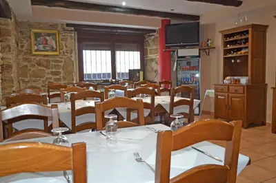 a dining room with white tables and wooden chairs at Hotel Rural Val Dos Pigarros in Lubián