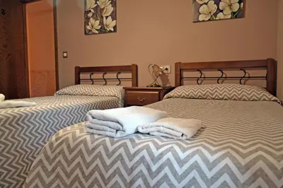 two beds with towels on them in a room at Hotel Rural Val Dos Pigarros in Lubián