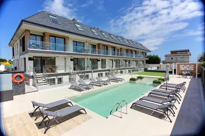 a house with a swimming pool and lounge chairs at Viviendas Vacacionales ENTREPLAYAS. Foz. in Foz