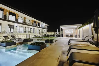 a hotel with a swimming pool at night at Viviendas Vacacionales ENTREPLAYAS. Foz. in Foz
