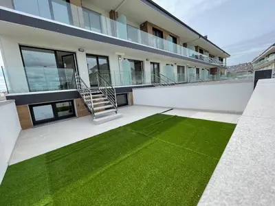 a house with a green lawn in front of it at Viviendas Vacacionales ENTREPLAYAS. Foz. in Foz