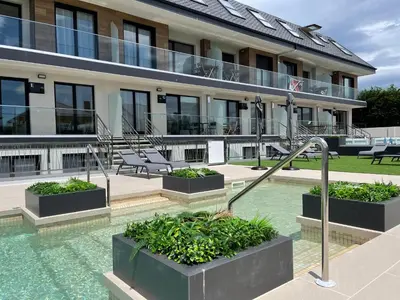 a building with a swimming pool in front of a building at Viviendas Vacacionales ENTREPLAYAS. Foz. in Foz