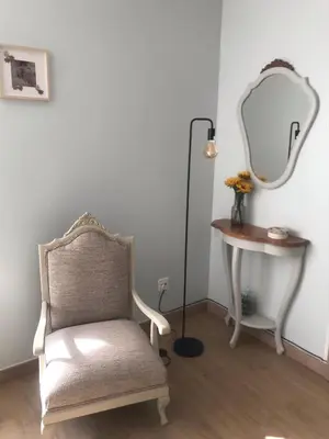 a chair and a table with a mirror and a lamp at El 0tro Cuartín in Ponferrada