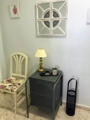 a table with a lamp and a chair in a room at El 0tro Cuartín in Ponferrada