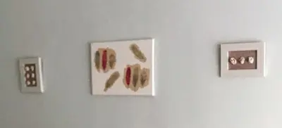 three pieces of art hanging on a white wall at El 0tro Cuartín in Ponferrada