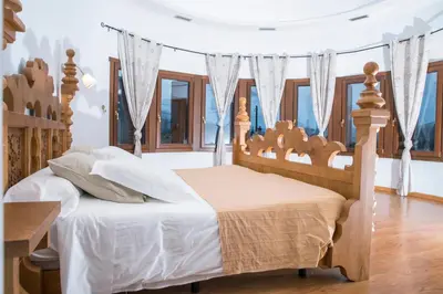 a bedroom with a bed with a wooden headboard and windows at Complejo Hostelero Paladium in Villamartín
