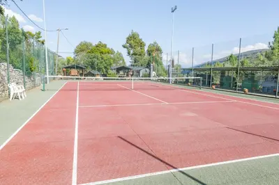 a tennis court with a net on top of it at Complejo Hostelero Paladium in Villamartín