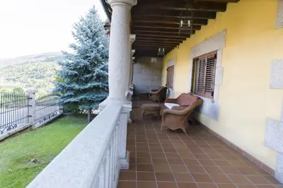 a porch of a house with a couch and a chair at Complejo Hostelero Paladium in Villamartín