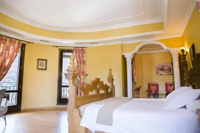 a bedroom with a white bed and yellow walls at Complejo Hostelero Paladium in Villamartín