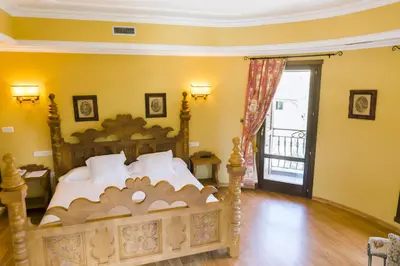 a bedroom with a bed and a door to a balcony at Complejo Hostelero Paladium in Villamartín