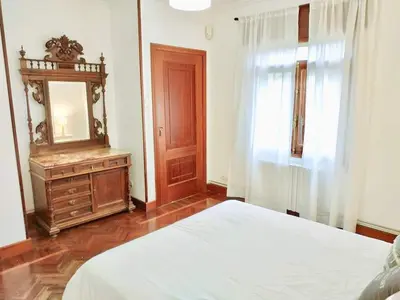a bedroom with a bed and a dresser and a mirror at Covas Beach Garden in Viveiro
