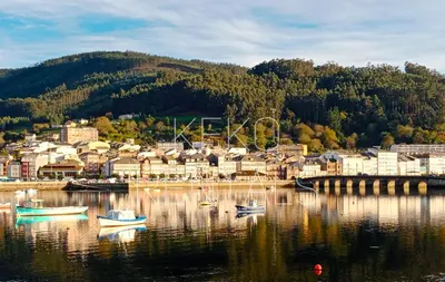 a small town on a lake with boats in the water at Covas Beach Garden in Viveiro
