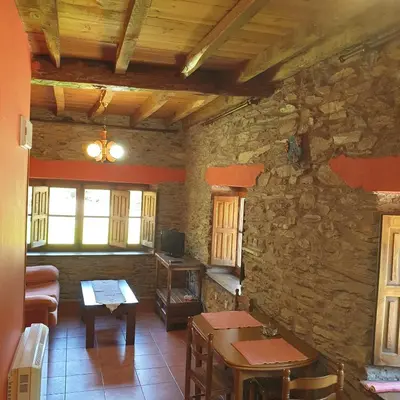 a kitchen with a table and a counter in a room at Valles del Narcea, Apartamentos Rurales in Cangas del Narcea
