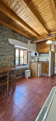 a rocking chair in a room with a kitchen at Valles del Narcea, Apartamentos Rurales in Cangas del Narcea