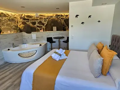 a bedroom with a tub and a bed and a tub at Loft con Jacuzzi os Arcos in Sober