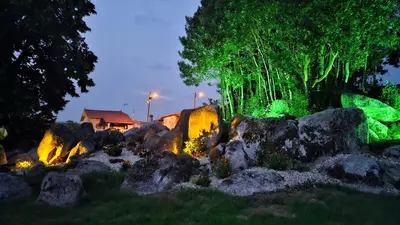 a garden with rocks and lights at night at Loft con Jacuzzi os Arcos in Sober