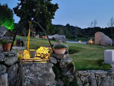 a garden with a rock wall with a swing at Loft con Jacuzzi os Arcos in Sober