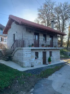 a stone house with a balcony and a porch at CASA TIO HERMINIO in O Irixo