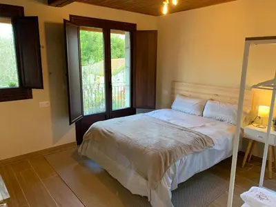 a bedroom with a bed and a window at CASA TIO HERMINIO in O Irixo