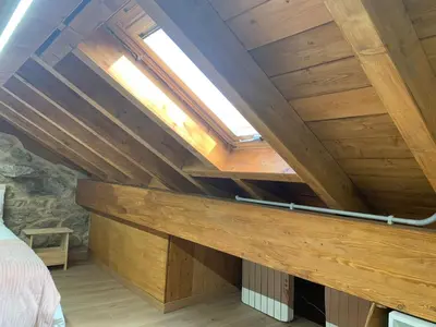 a room with wooden walls and a ceiling with a skylight at CASA TIO HERMINIO in O Irixo