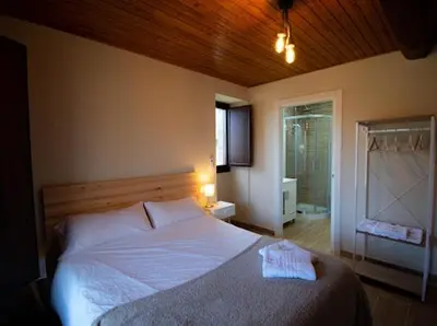 a bedroom with a large bed and a window at CASA TIO HERMINIO in O Irixo