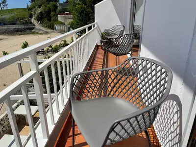 two chairs sitting on a balcony with the beach at Oktheway Perbes Beach 2 in Boebre