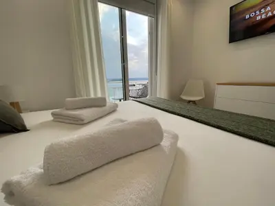 a bedroom with a white bed with a large window at Oktheway Perbes Beach 2 in Boebre