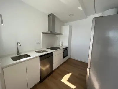 a kitchen with white cabinets and a stainless steel refrigerator at Oktheway Perbes Beach 2 in Boebre