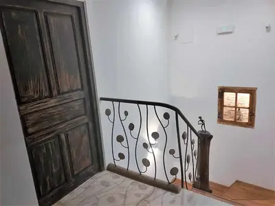 a stairway with a wooden door next to a stair case at Casa Rural Estrella del Sil in Corbón del Sil