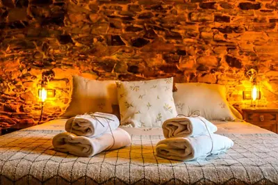 a bedroom with a bed with towels on it at Fogar de Lecer in Arzúa