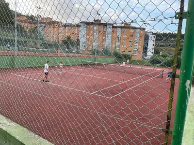 a group of people playing tennis on a tennis court at AREA PLAYA VIVEIRO APARTAMENTS , XOVE in Jove