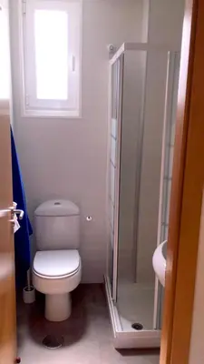 a bathroom with a toilet and a glass shower at AREA PLAYA VIVEIRO APARTAMENTS , XOVE in Jove