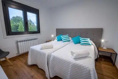 a bedroom with two beds with white and blue pillows at Finca Bacelo Ribeira Sacra in Sober