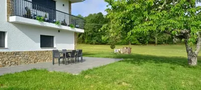 a patio with a table and chairs next to a building at Finca Bacelo Ribeira Sacra in Sober