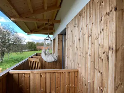 a wooden building with a porch with a swing at Rectoral de Boente in Arzúa