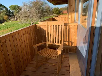 a wooden chair sitting on the porch of a house at Rectoral de Boente in Arzúa