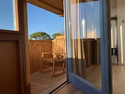 a sliding glass door leading to a patio with a chair at Rectoral de Boente in Arzúa