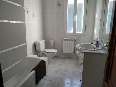 a white bathroom with a toilet and a sink at Vista Estrelada in Requeixo