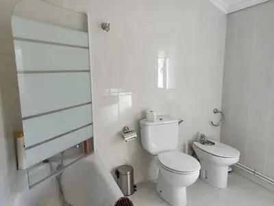 a white bathroom with a toilet and a bath tub at Vista Estrelada in Requeixo