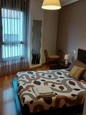 a bedroom with a bed with a cow blanket on it at Piso Lomberte in Allariz