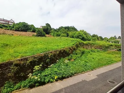 a field of grass next to a road at Indiano 4B in Viveiro