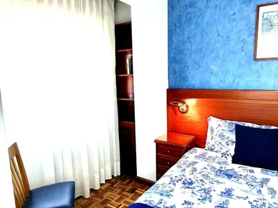 a bedroom with a bed and a blue wall at Piso en pleno centro de Miño derecha in Miño