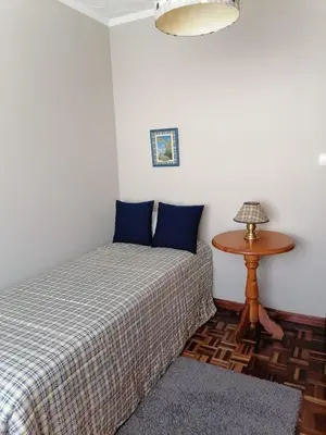 a bedroom with two beds and a table with a lamp at Piso en pleno centro de Miño derecha in Miño
