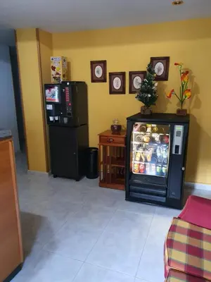 a living room with a refrigerator and a table at Pension A Barca in O Barco de Valdeorras