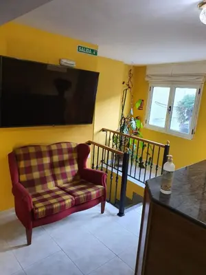 a living room with a couch and a flat screen tv at Pension A Barca in O Barco de Valdeorras