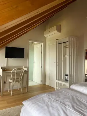 a bedroom with a bed and a desk with a chair at Boutique Finca esencial Hotel Rural in Villafranca del Bierzo