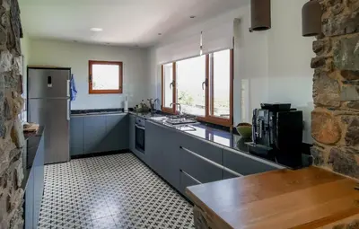 a kitchen with a refrigerator and a counter top at Boutique Finca esencial Hotel Rural in Villafranca del Bierzo