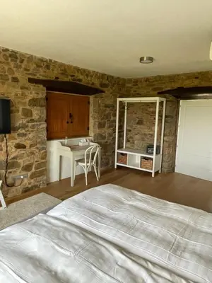 a bedroom with a bed and a stone wall at Boutique Finca esencial Hotel Rural in Villafranca del Bierzo