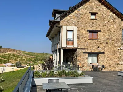 a stone house with a patio and a table at Boutique Finca esencial Hotel Rural in Villafranca del Bierzo